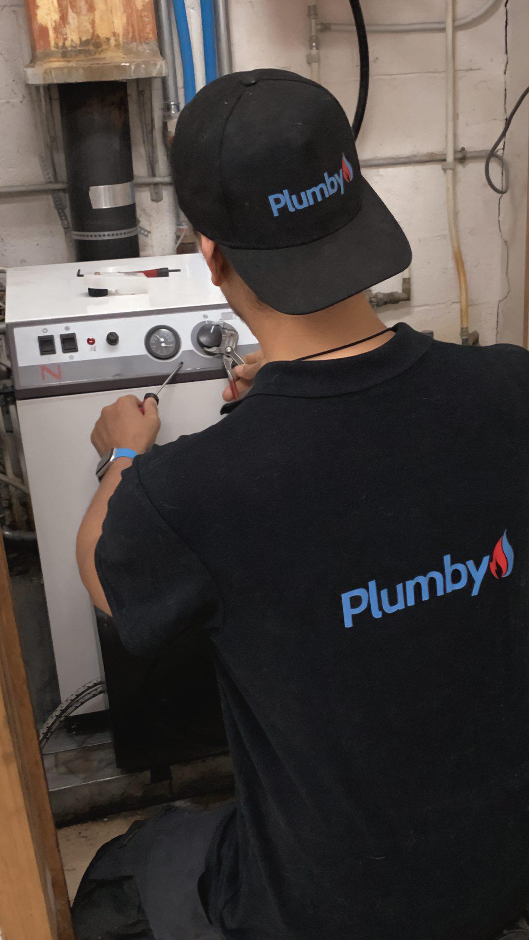 Technicien Plumby effectuant l'entretien d'une chaudière