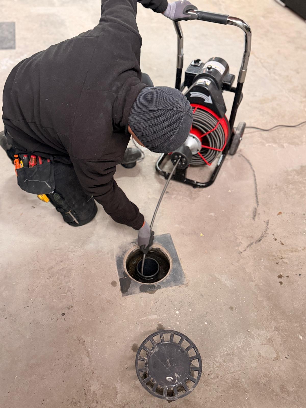 Plombier Plumby débouchant une canalisation au furet électrique — Plombier à Butgenbach
